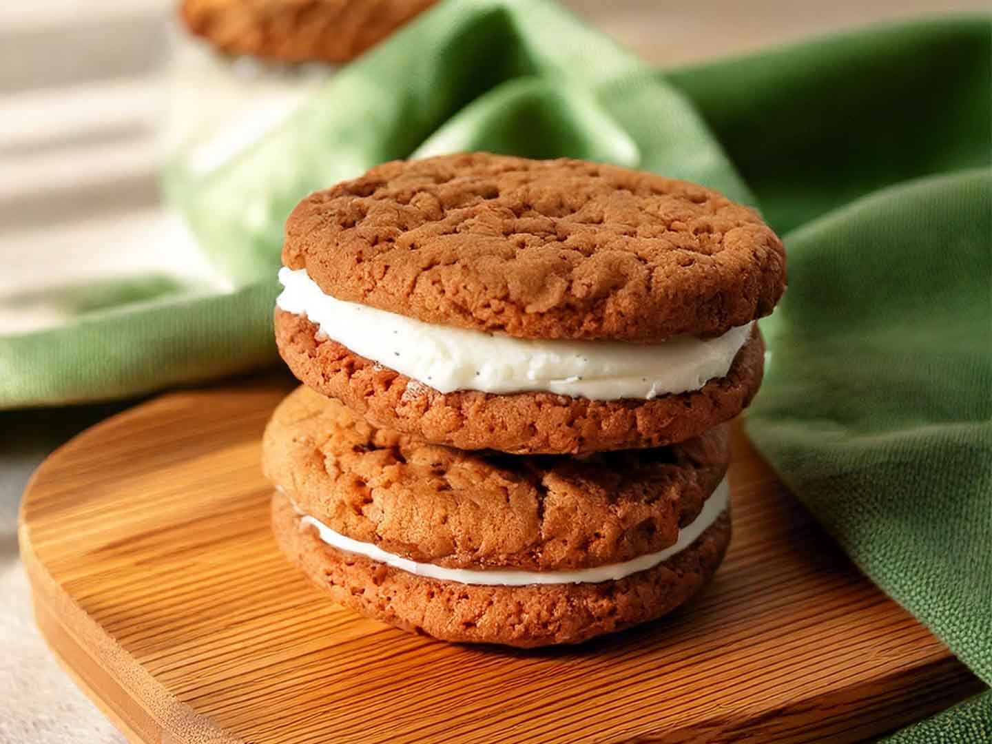 Oat cookie ice cream sandwiches stacked on a wooden board