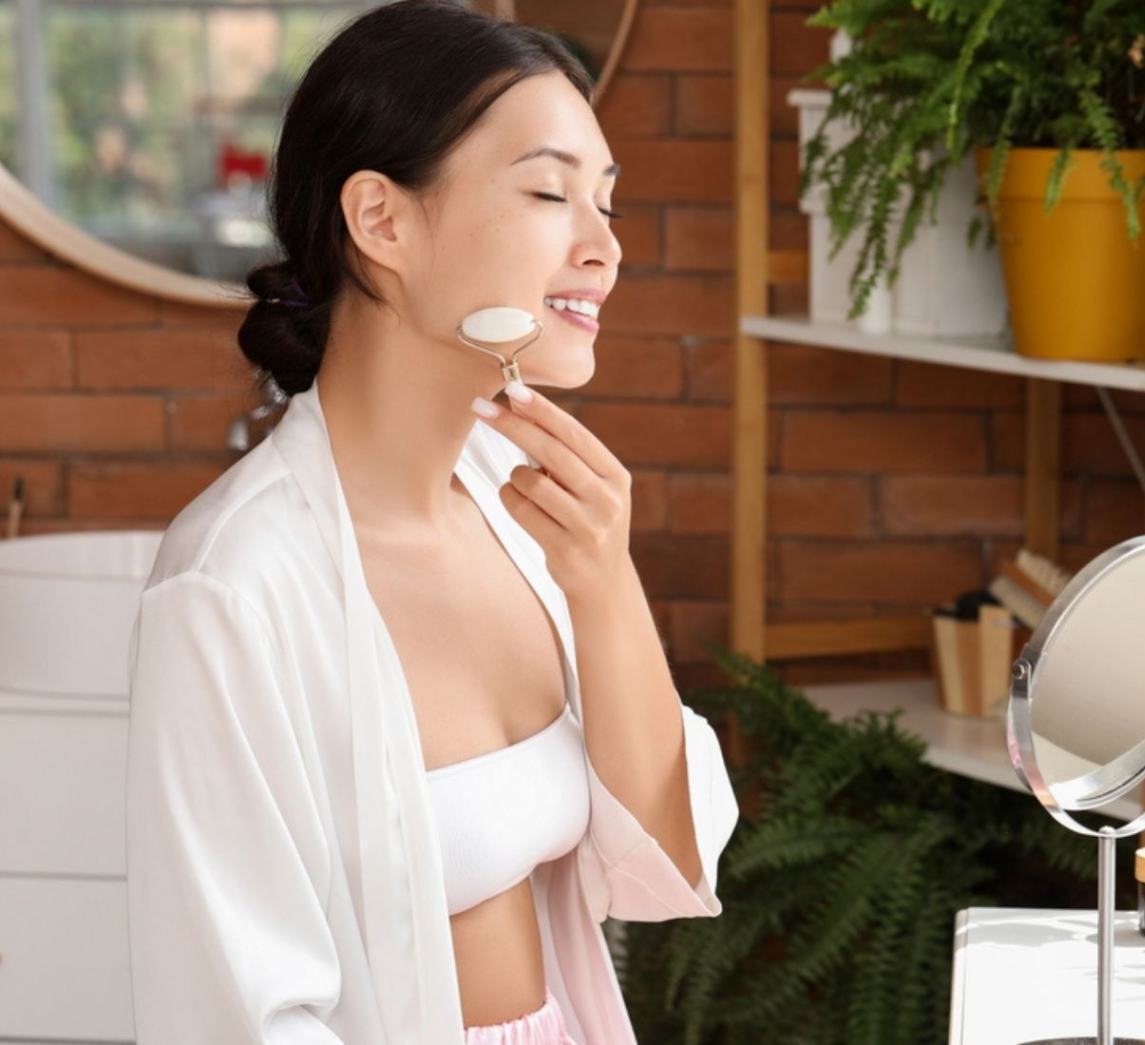 Woman massaging her face with a jade roller.