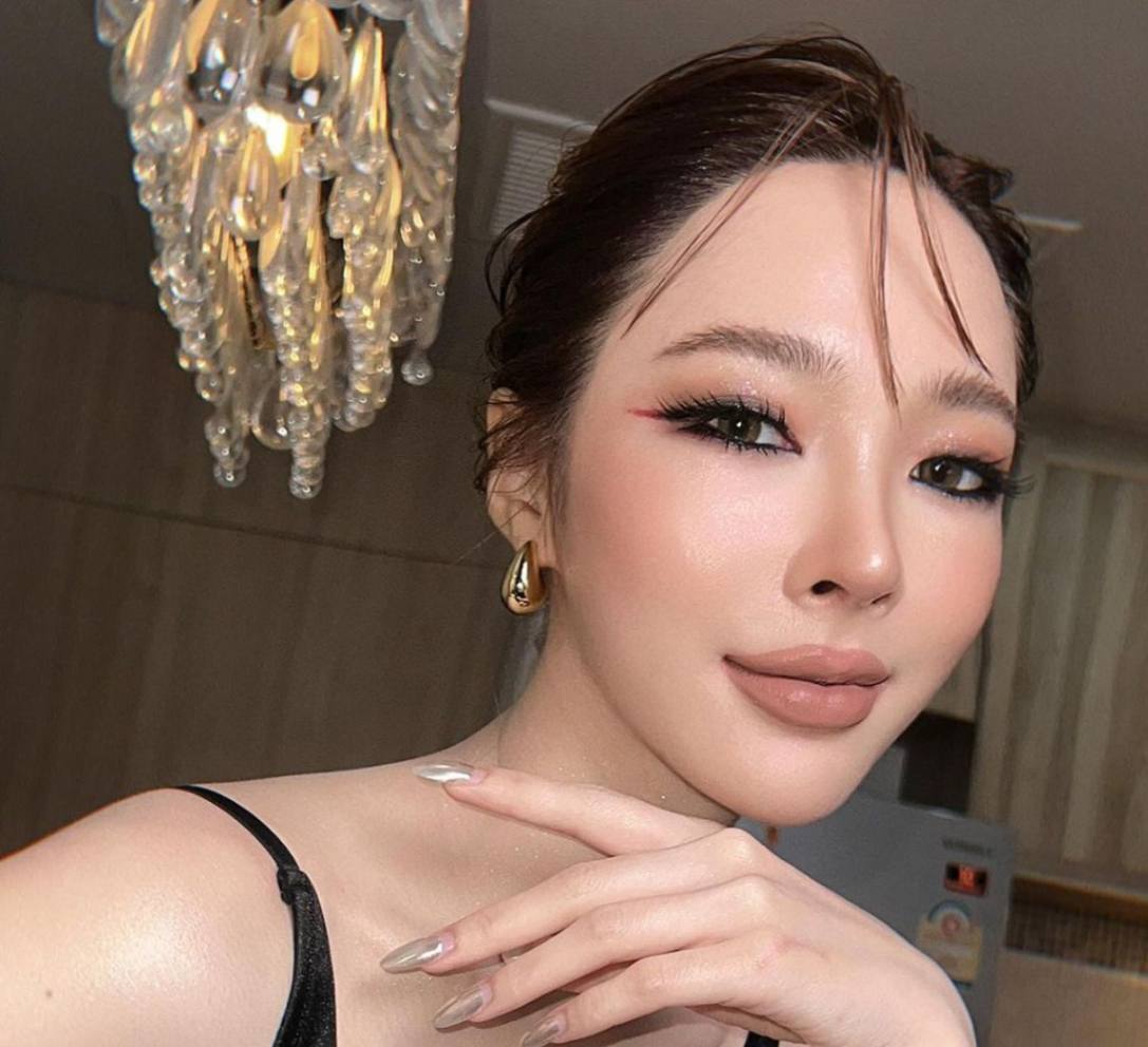 A portrait of woman with bold eye makeup and nude lips.