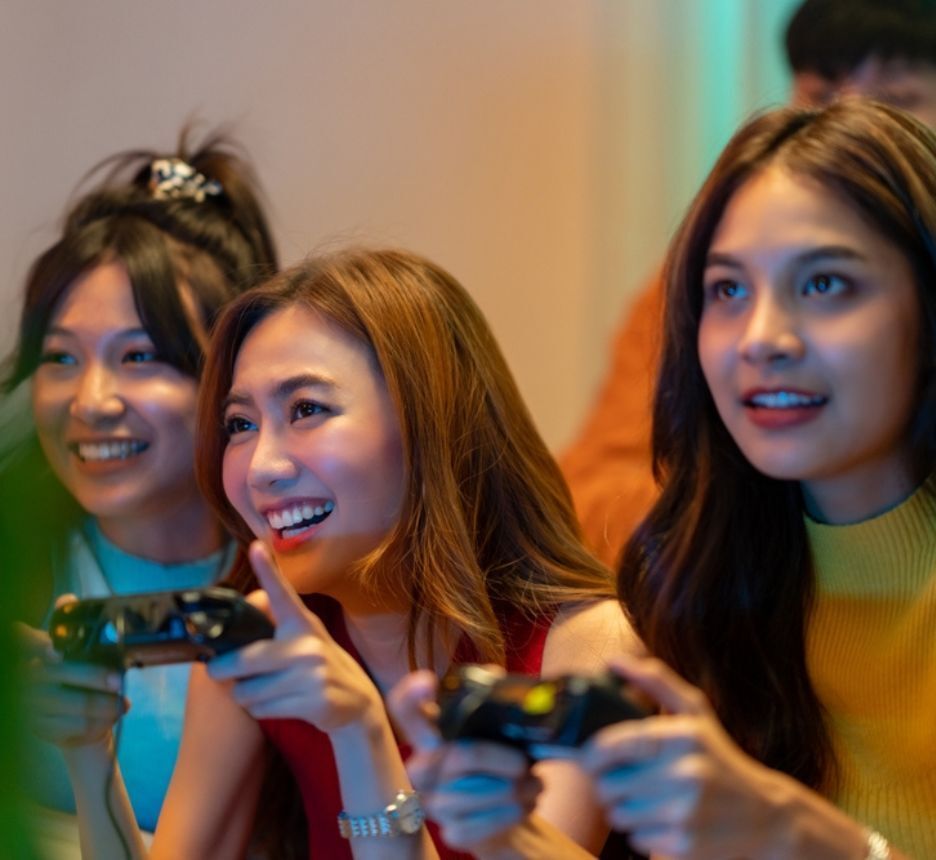 Three women playing video games with joysticks.