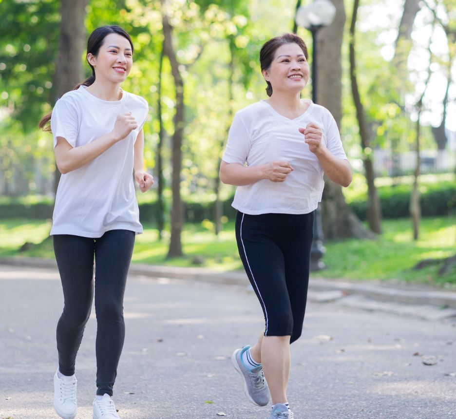 Mother and daughter jogging together outdoors.