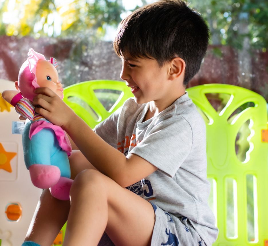 Little boy playing with doll.