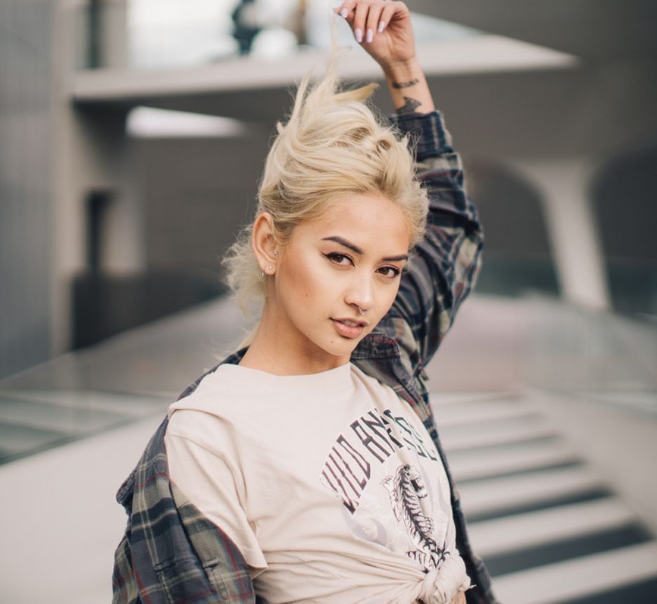Woman with platinum blonde hair and grunge outfit.