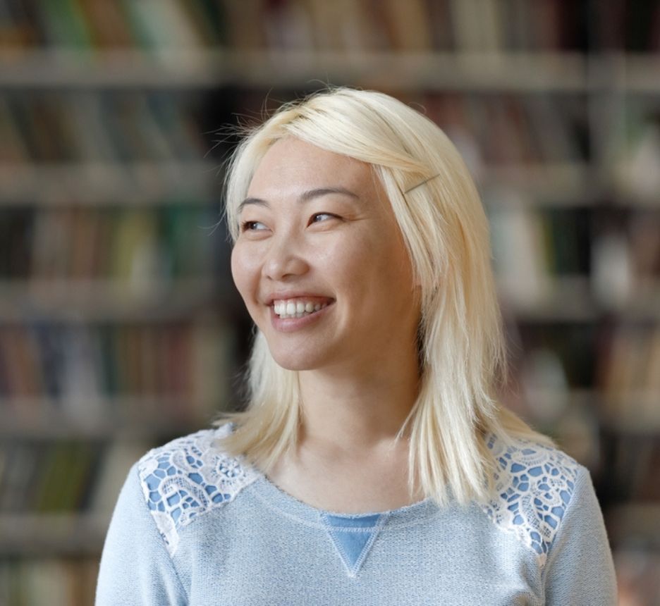 A hair colorist bleaching her client’s long hair.