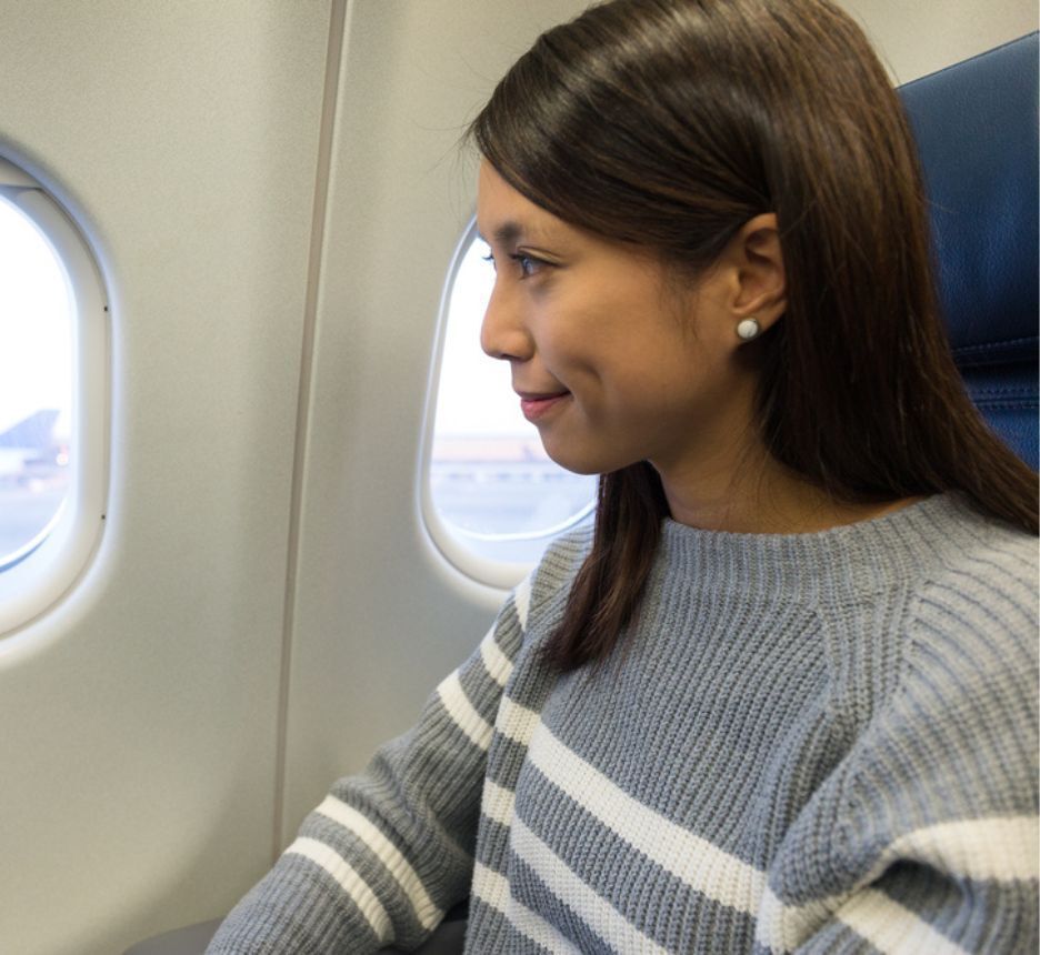 Asian woman looking out from an airplane window.