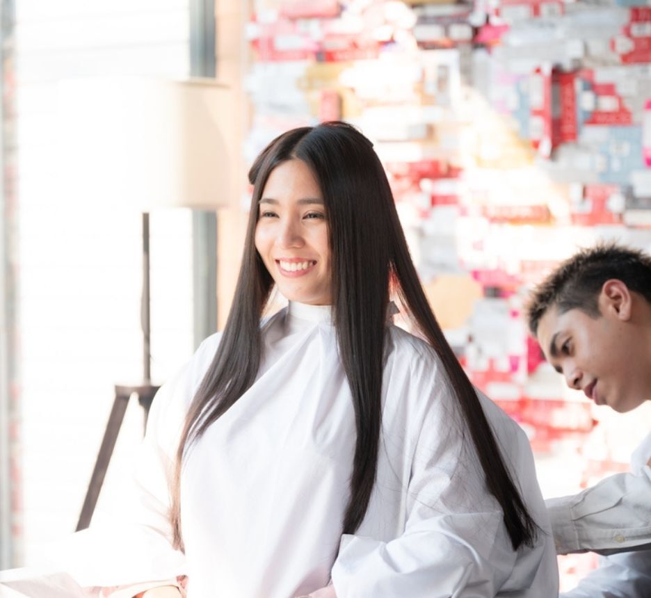 Woman with long, straight hair getting a haircut.