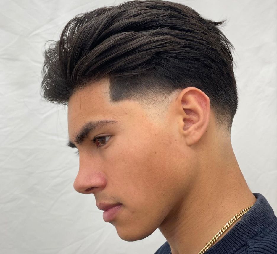 Man with low fade and medium-length brown hair.