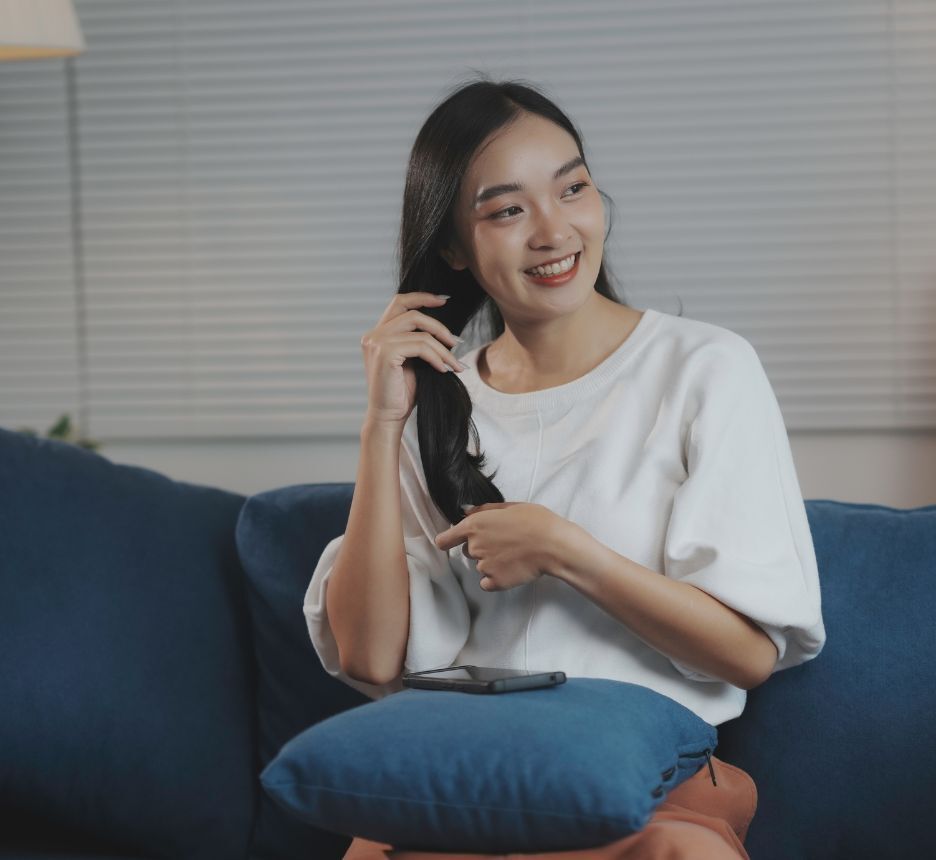 Woman touching her long, black hair.