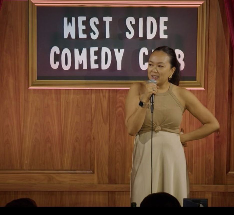 Female comedian in brown top at a comedy club.