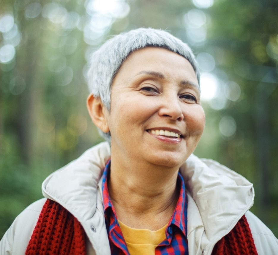 Woman with short, graying hair smiling to the camera.