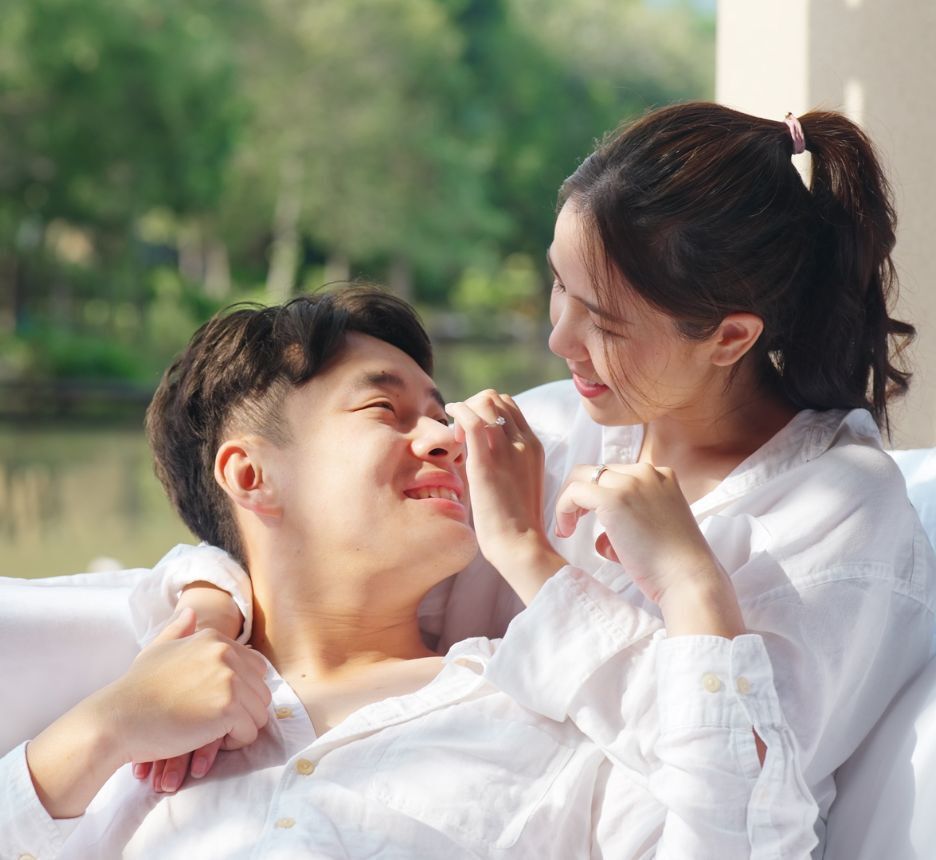 Man laying down on a woman’s lap lovingly.