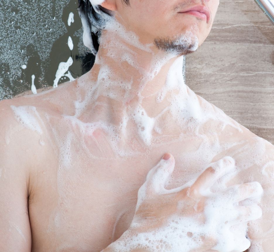 A man’s torso covered in soap suds.