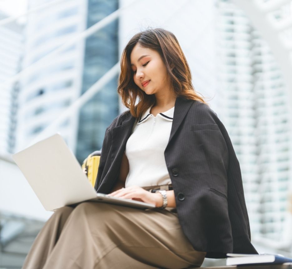 Woman with shoulder-length hair working with her laptop.