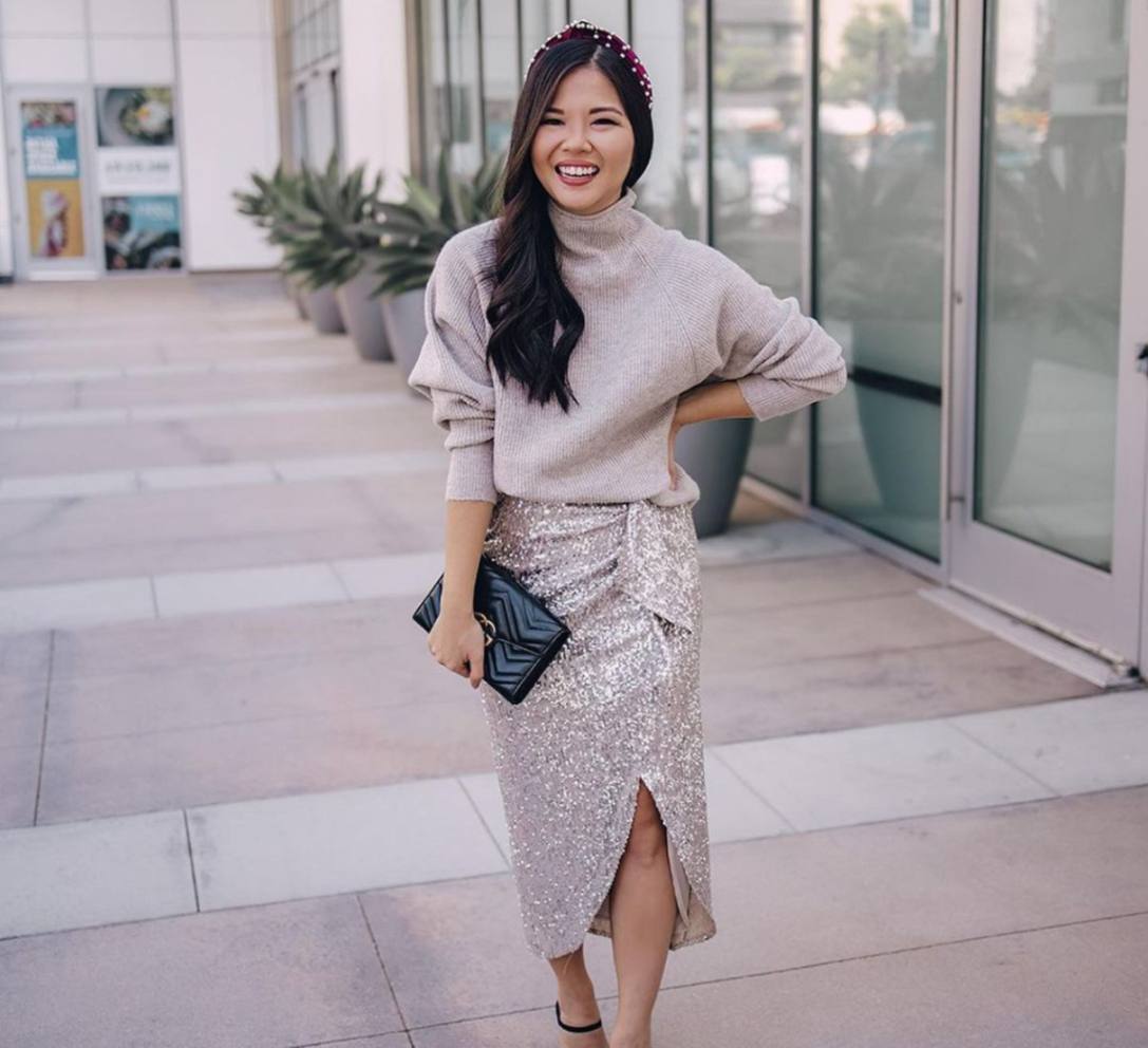 Woman wearing sweater and sequined maxi skirt. 