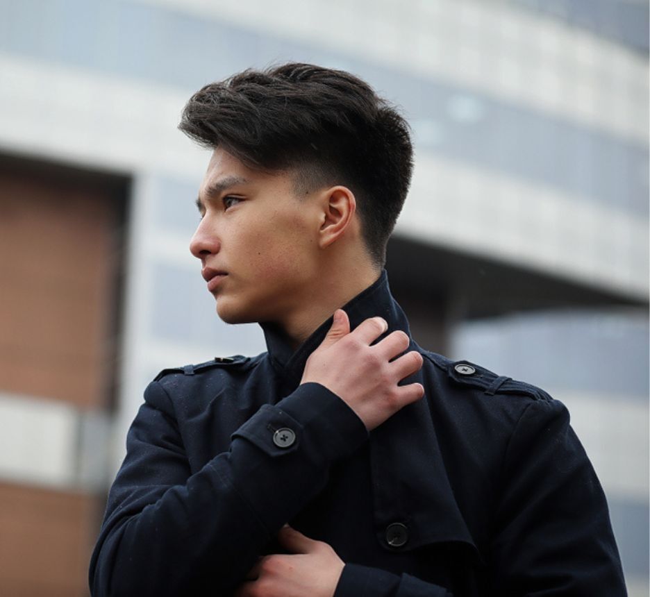 Man with classic fade wearing all-black attire.