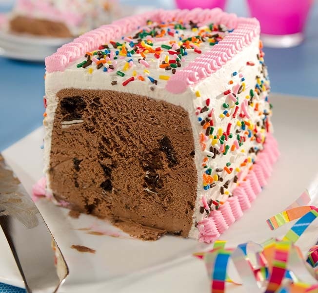Slice of party cake with sprinkles and chocolate ice cream inside