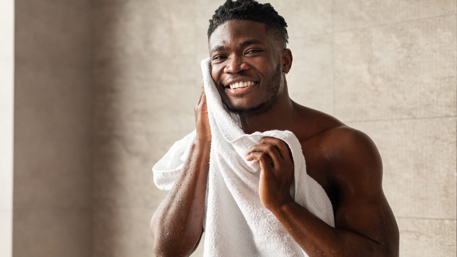 Man wiping his face after having a shower