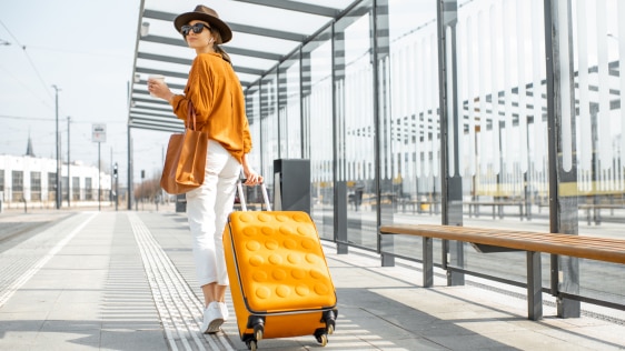 Young female traveler with her luggage that contains bar soap