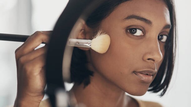 Concealer or Foundation? What is the Difference? woman dark skin brush