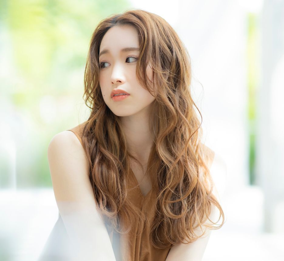 tóc xù tóc dài uốn xù nhẹ cô gái đang nhìn sang bên trái phía sau bị làm mờ