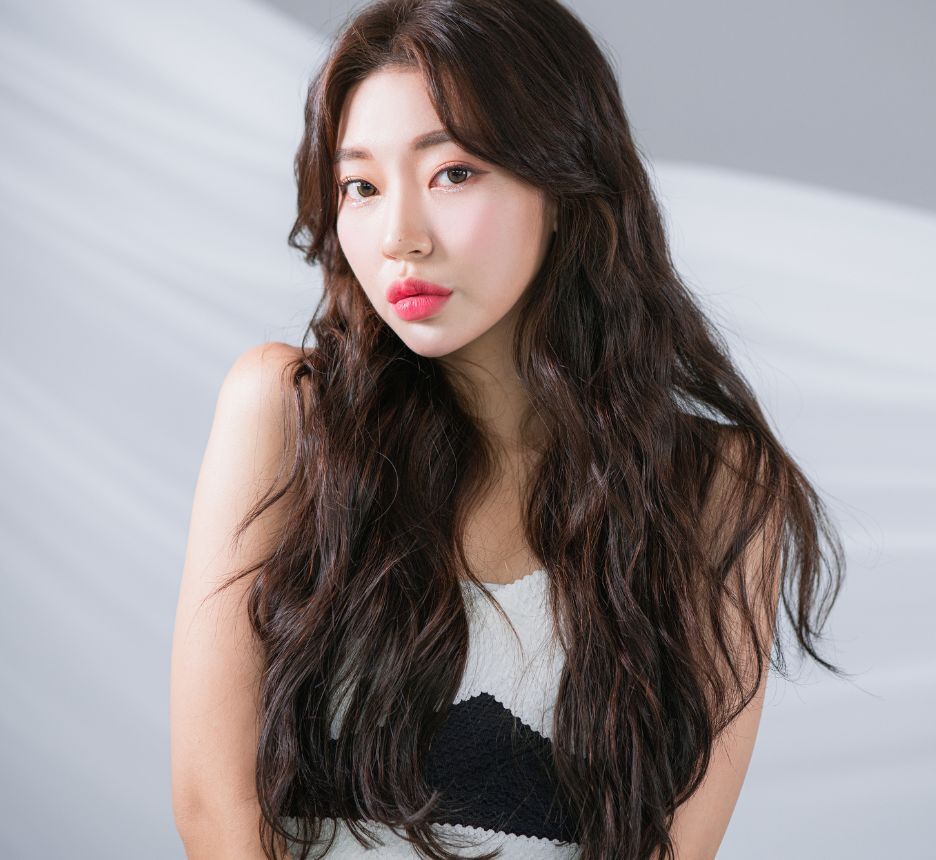 tóc xù tóc xù mì tôm dài cô gái đang nhún vai trên nền tường xám