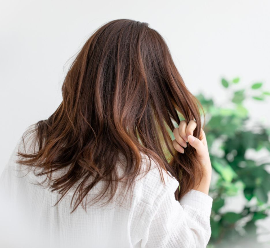 tóc xù gỡ rối tóc đúng cách ảnh chụp phía sau cô gái đang luồn bàn tay vào tóc