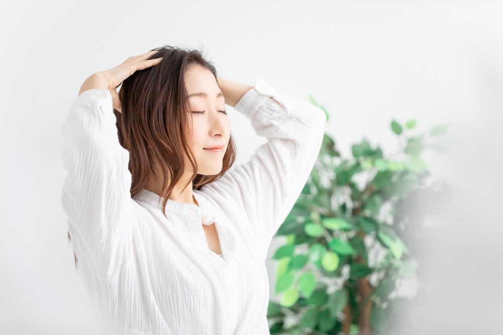 ngứa da đầu về đêm cô gái mặc áo sơ mi trắng đang luồn tay vào tóc