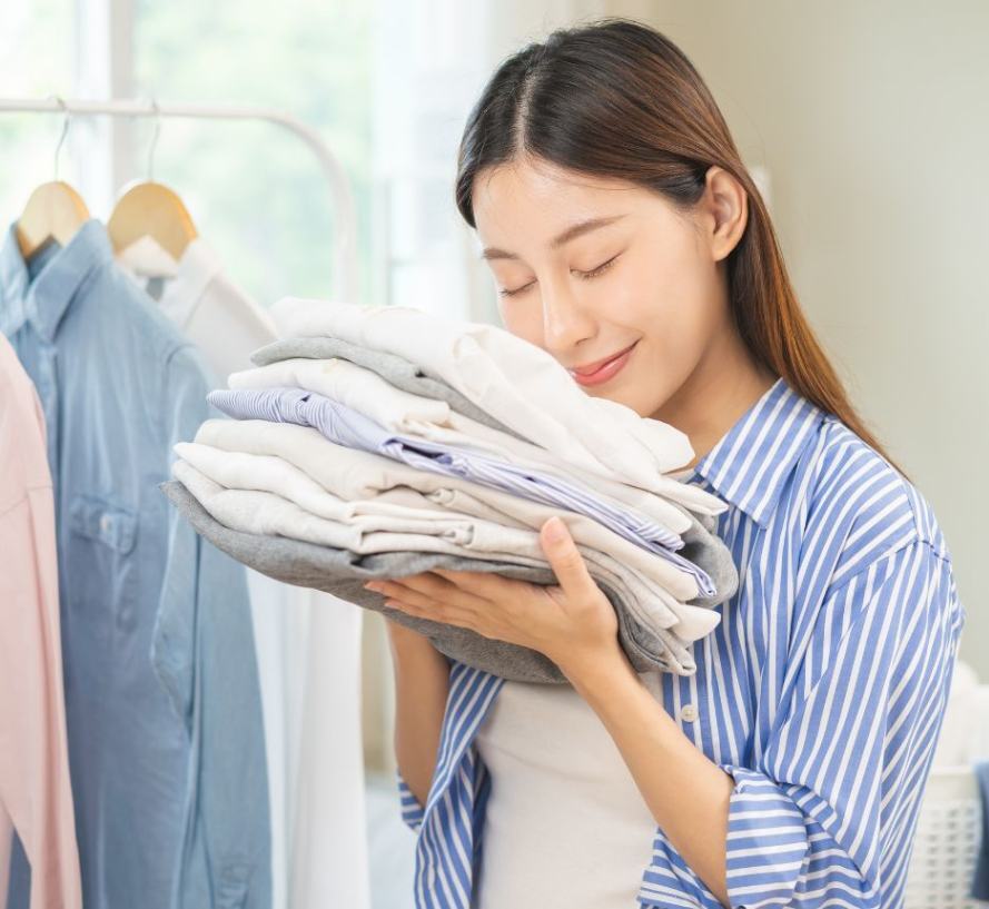 cách trị mụn ở mông mặc quần áo rộng và thoải mái cô gái mặc áo sơ mi kẻ sọc tay đang ôm chồng quần áo