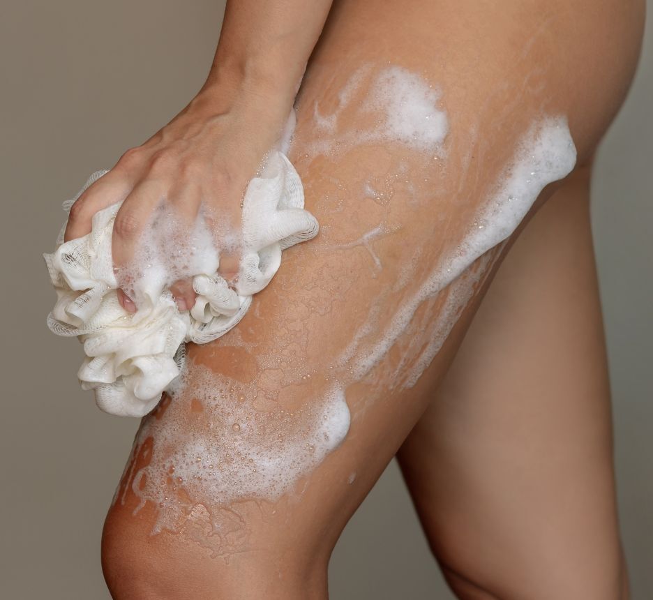 cách trị mụn ở mông chú ý vệ sinh cơ thể cô gái đang dùng bông tắm làm sạch vùng da từ mông đến đùi