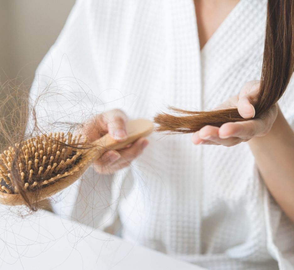 rụng tóc thiếu chất gì bàn tay cầm lược gỗ dính đầy tóc rụng