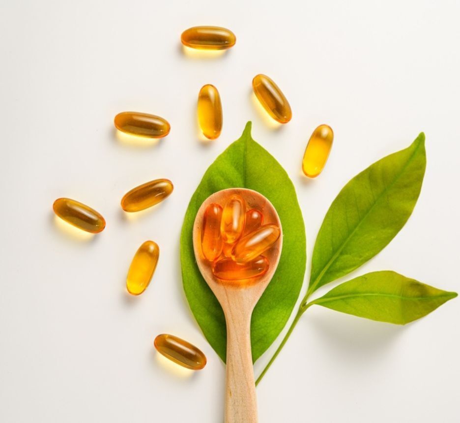 rụng tóc thiếu chất gì bổ sung vừa đủ vitamin những viên thuốc đặt trong thìa gỗ và xếp trên bàn