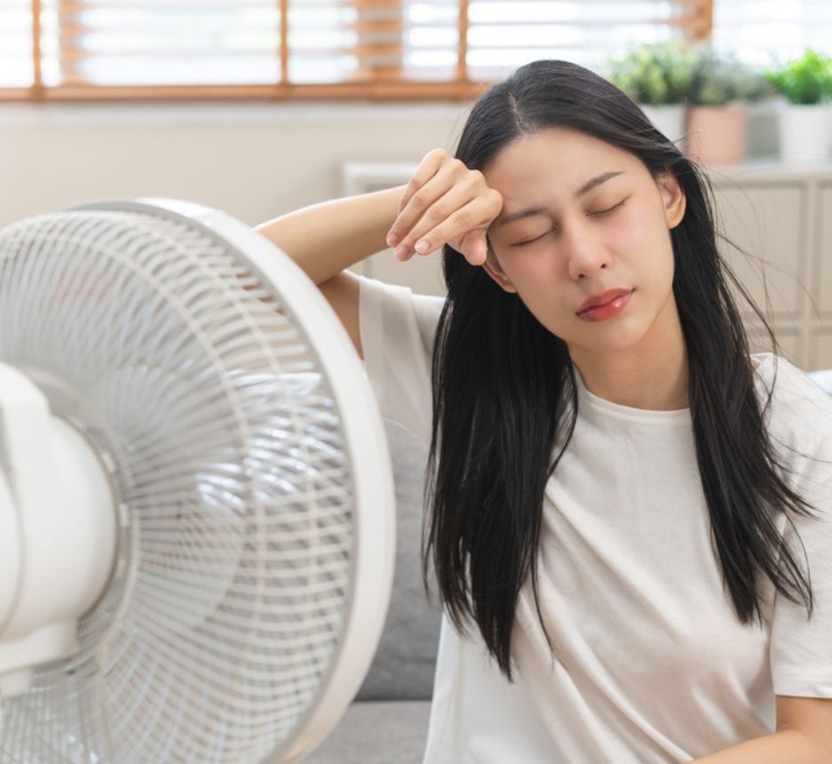 ngứa da đầu về đêm cơ thể đổ mồ hôi nhiều cô gái đang ngồi hóng gió trước quạt