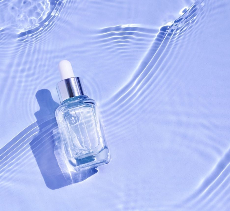 cách chăm sóc da thường cấp nước cho da chai đựng serum trong suốt trên nền tím