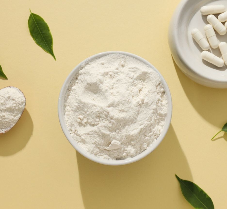 vitamin b5 có tác dụng gì cho tóc gội đầu bằng Vitamin B5 bột trắng đựng trong bát sứ bên cạnh là thìa gỗ và đĩa thuốc