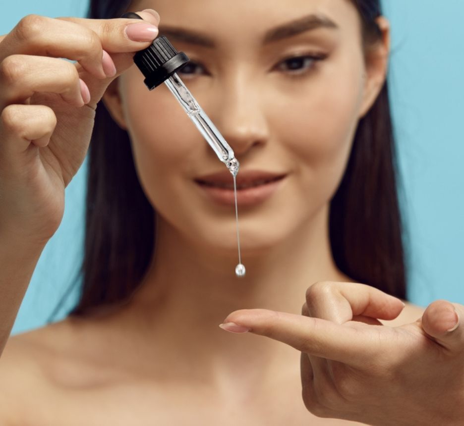 dầu dưỡng Dầu dưỡng da mặt là gì cô gái đang nhỏ giọt dưỡng chất lên ngón tay