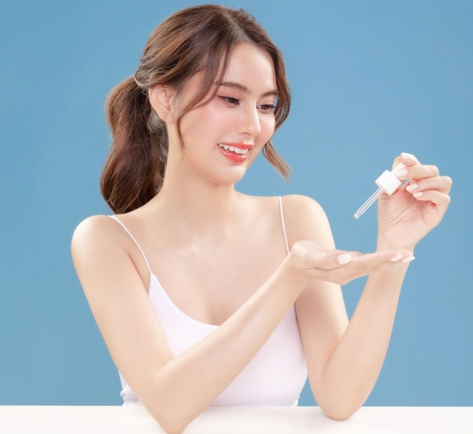 dầu dưỡng da sử dụng lượng vừa đủ cô gái đang nhỏ dầu dưỡng lên lòng bàn tay