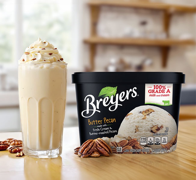 Creamy Butter Pecan Frozen Milkshake next to a tub of Breyers Butter Pecan.