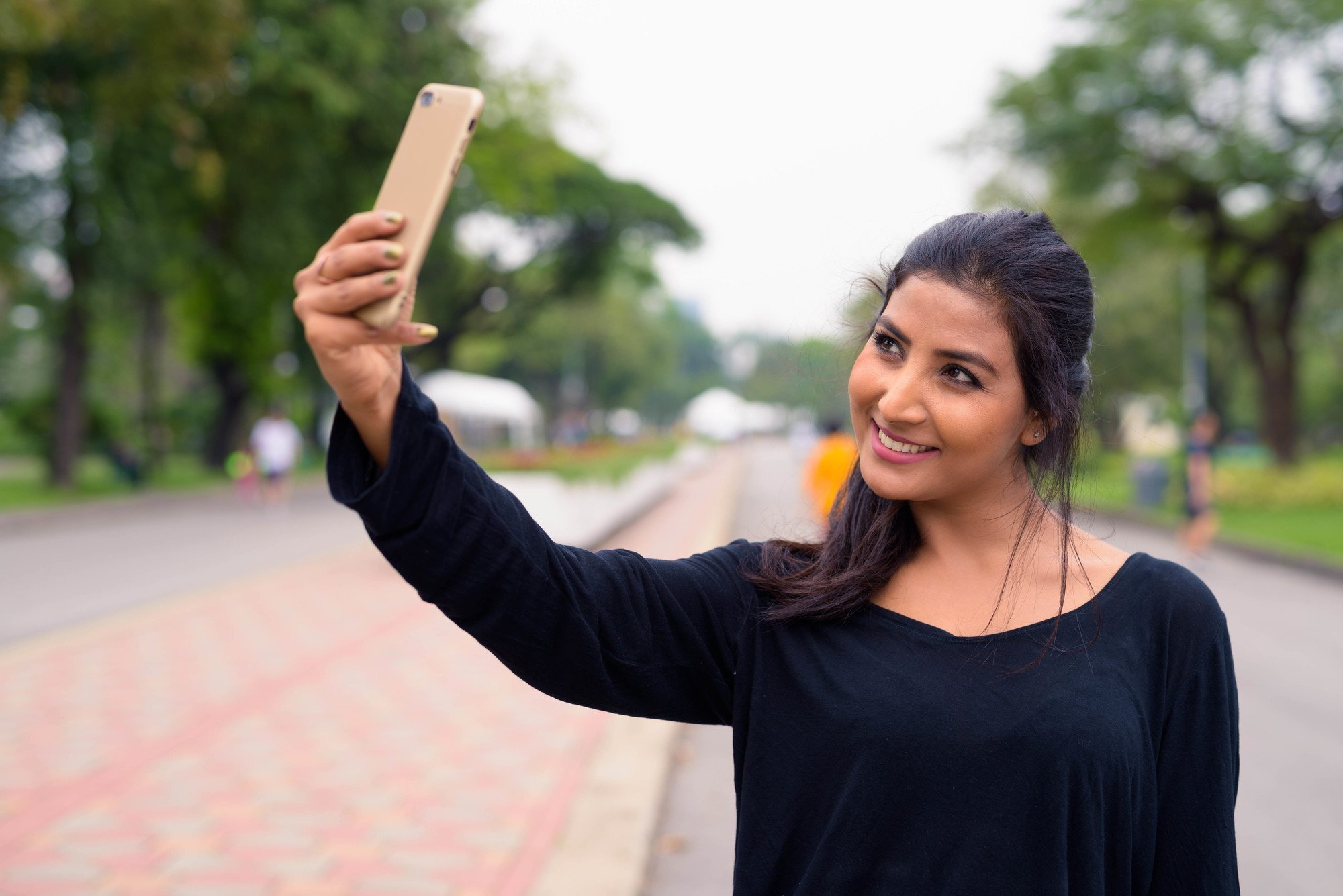 woman with a low ponytail hairstyle taking a selfie