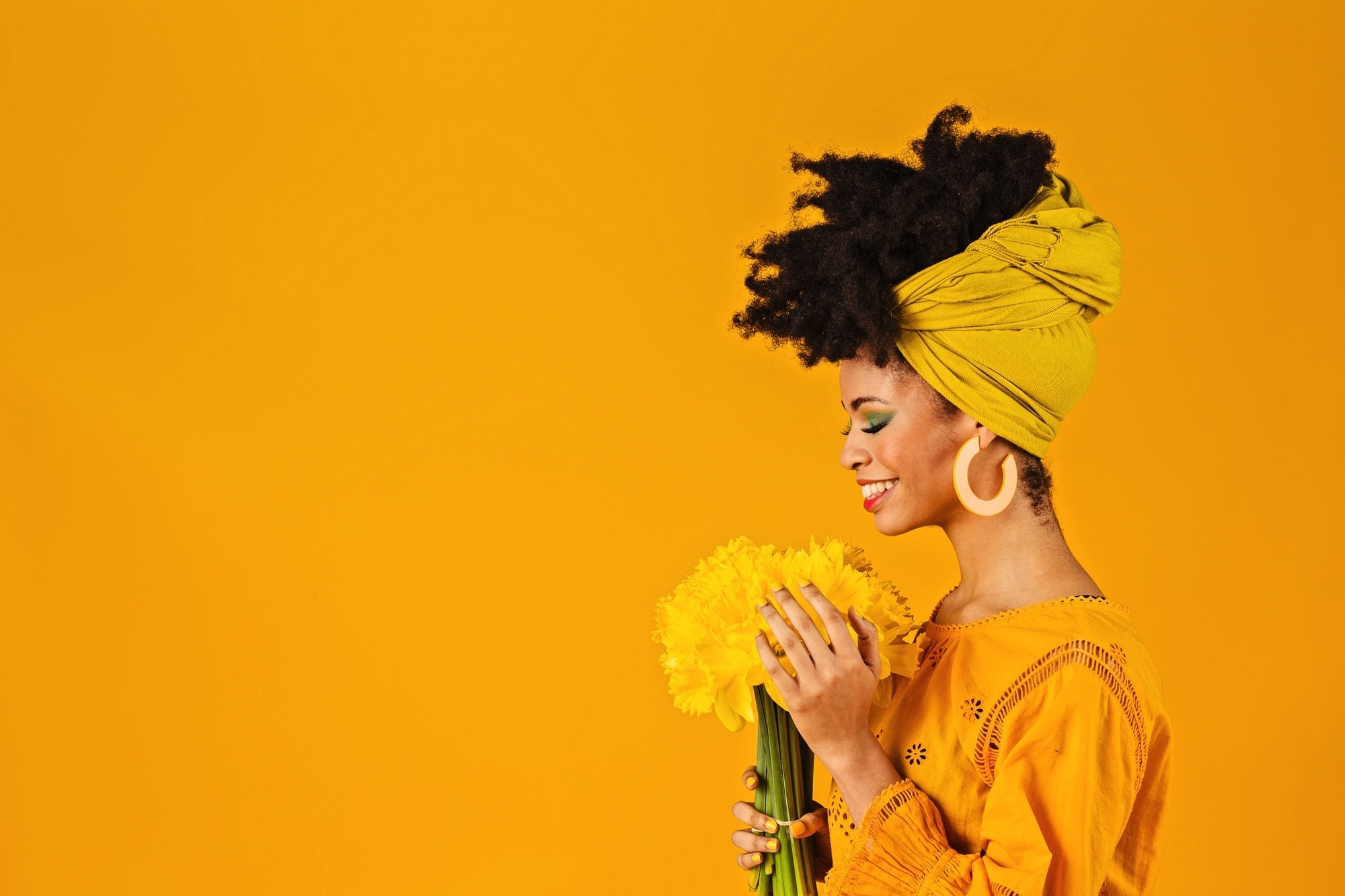 Woman with natural curls wearing a yellow headscarf