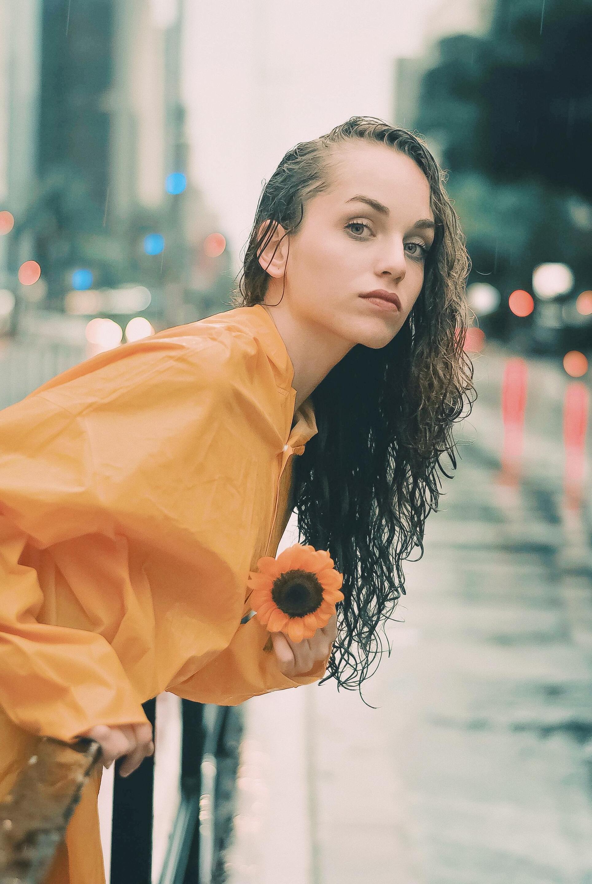 woman with long brown hair styled in a wet look with the hair swept over one shoulder