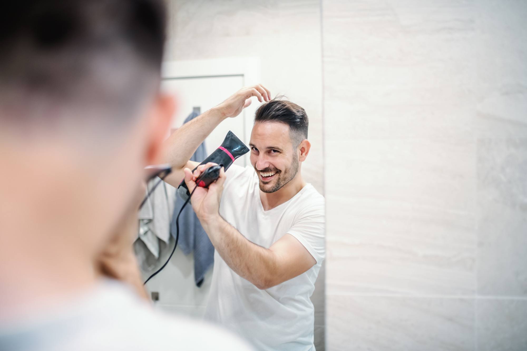 man blowdrying his hair