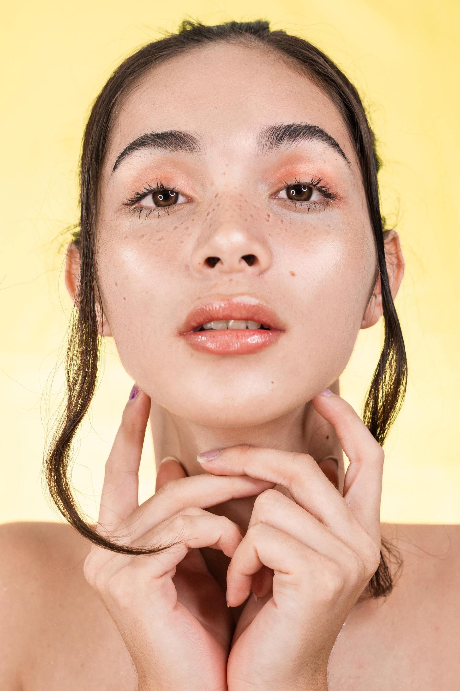 woman with a sleek updo and two pieces of hair framing her face