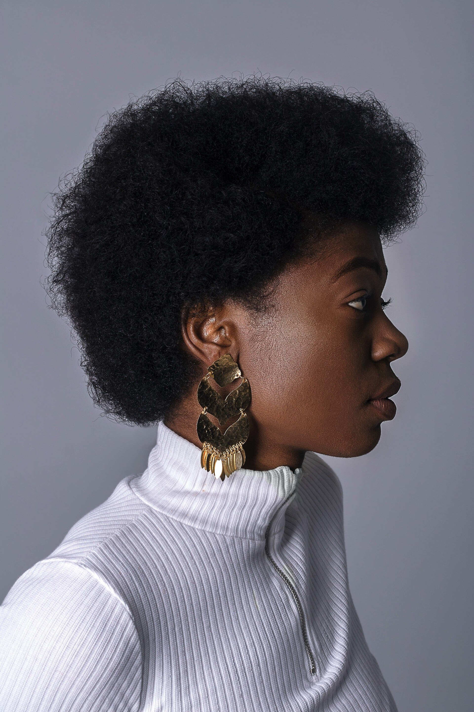 world afro day: woman with a white polar neck shirt and a big fluffy afro hairstyle