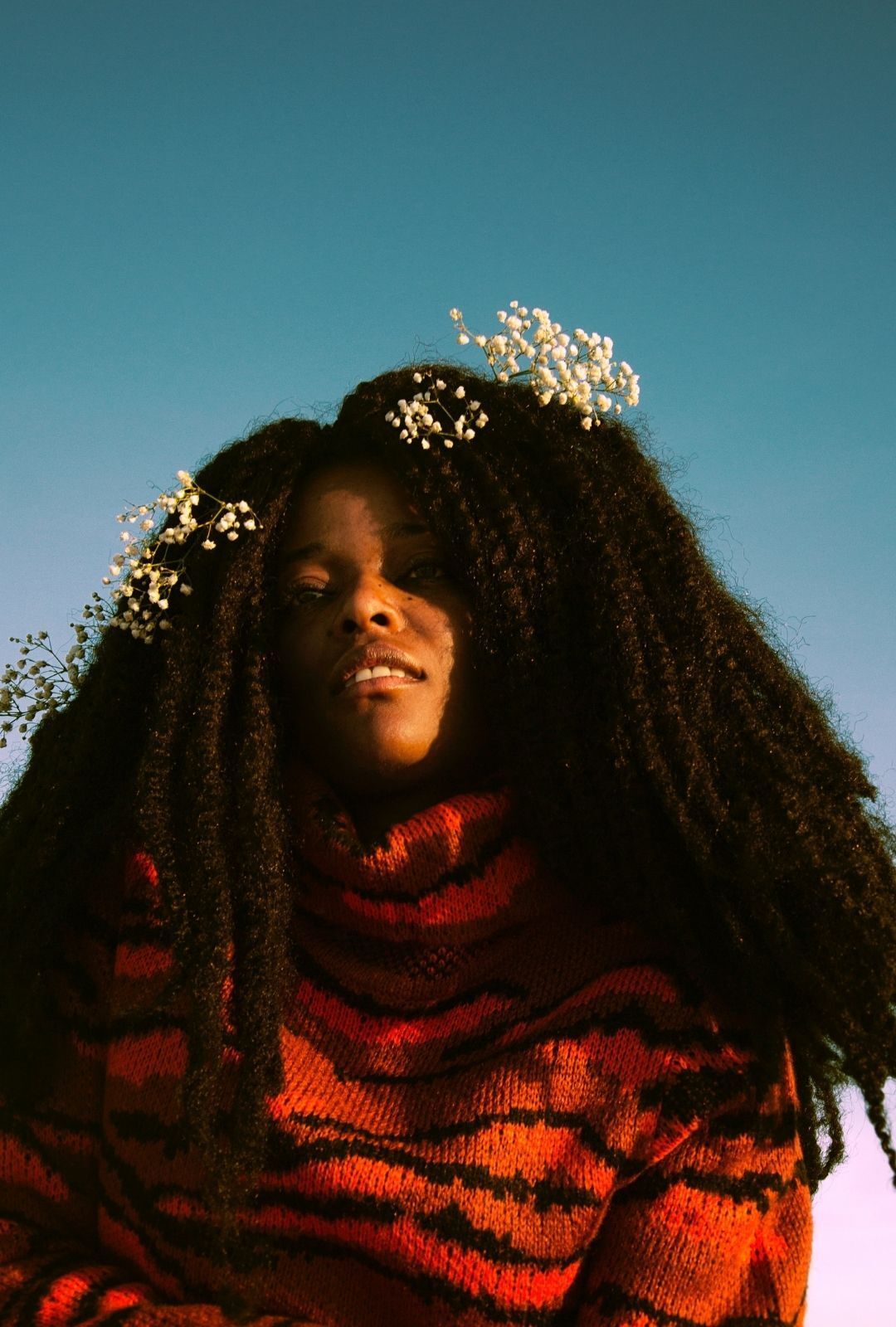 hair growth cycle: image of a woman with long natural hair and flower accessories framing her face