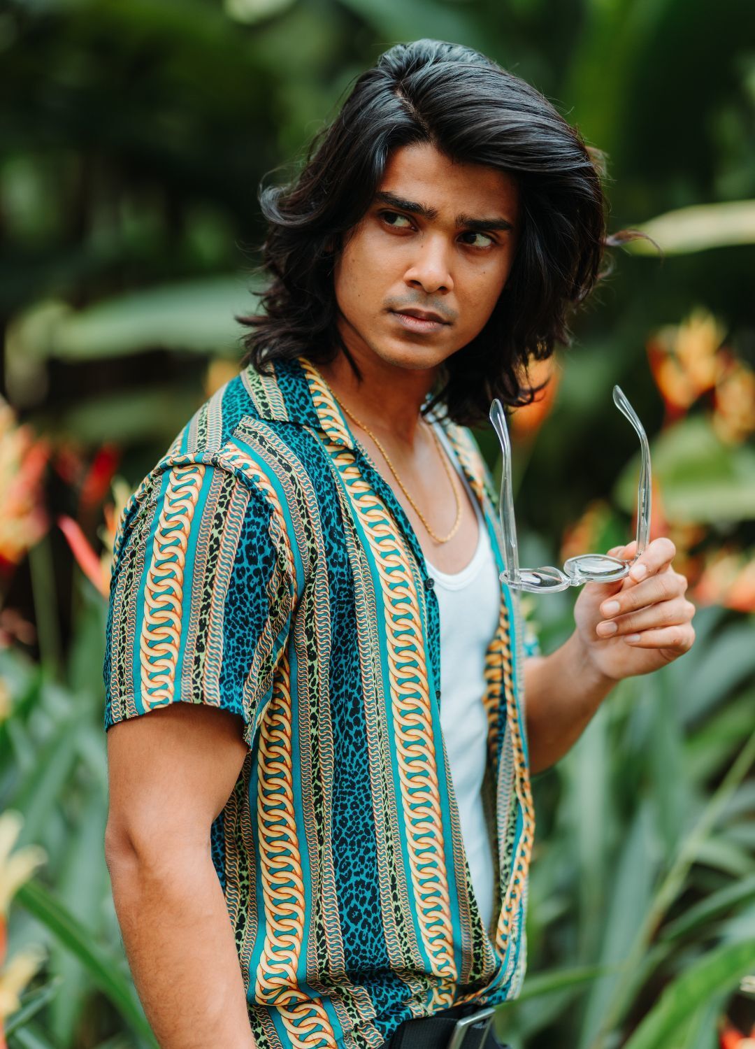man with thick, shoulder-length straight hair that has a deep side path and loads of volume