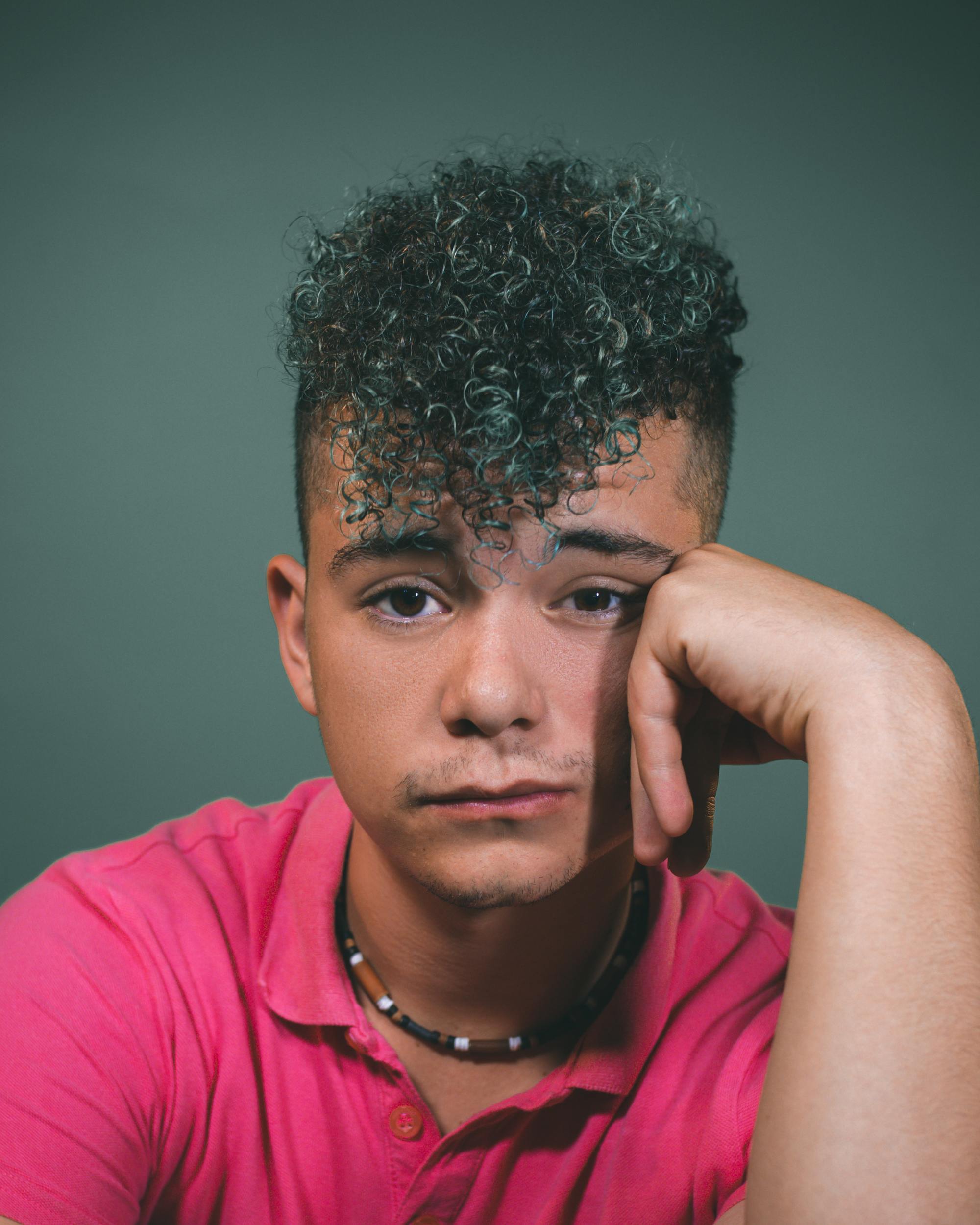 Stranger Things hairstyles: man with curly hair styled into a pompadour hairstyle, with short, faded sides