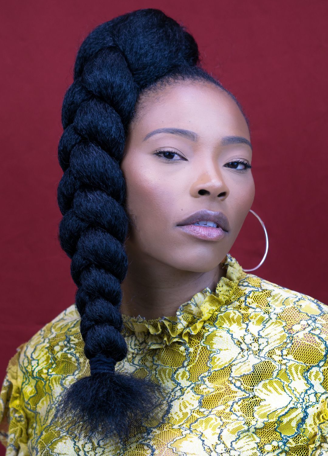 woman with her hair tied up into a high ponytail with a long plait