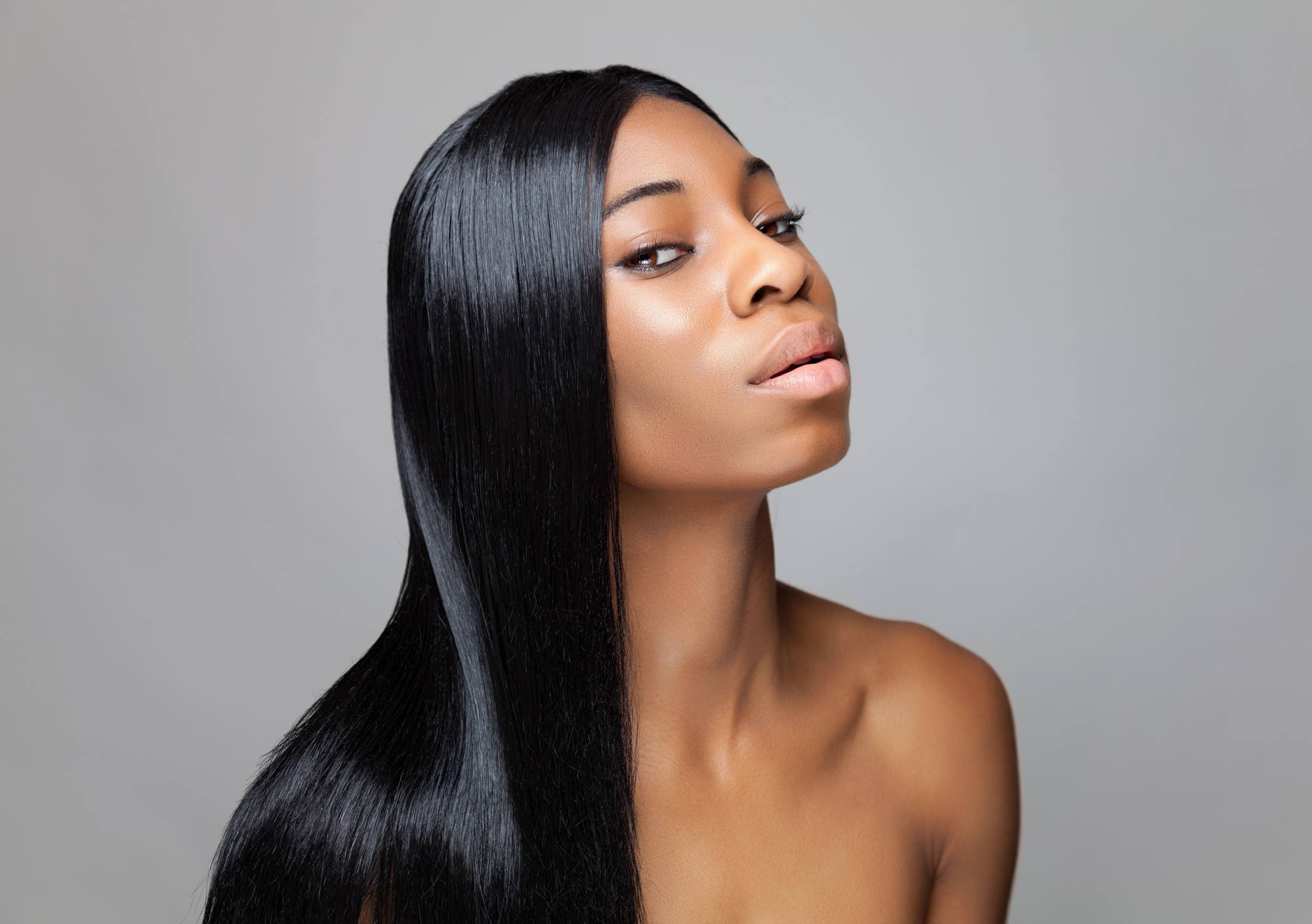 Woman with long black hair in a seek middle part hairstyle