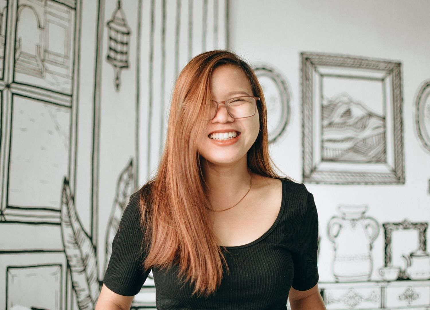 woman with long, sleek copper hair styled in a side path