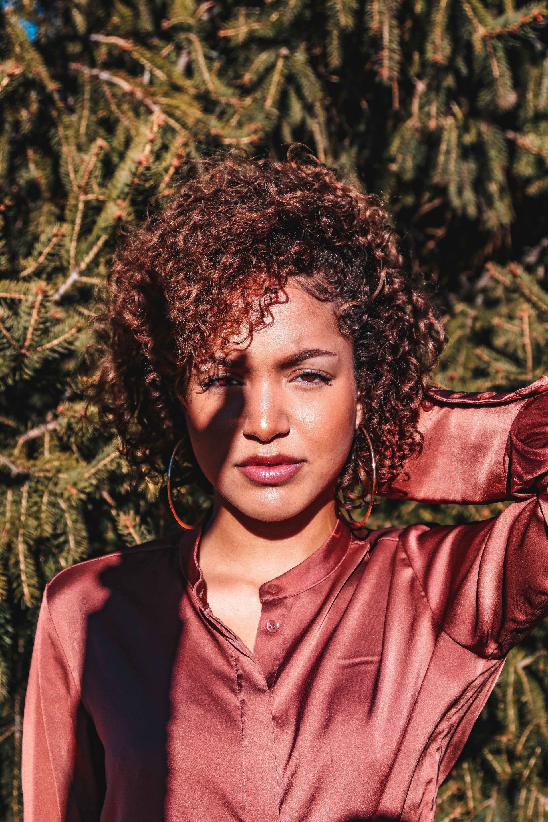 woman with jaw-length, copper-coloured naturally curly hair